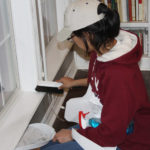 Melissa Espinoza cleaning windowsill